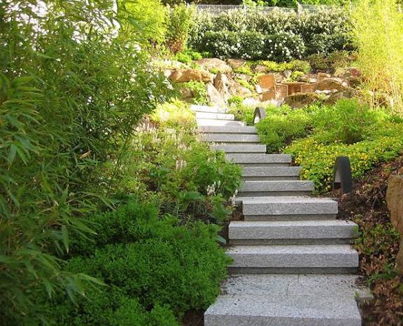 Gartenanlage mit Steintreppe, Bepflanzung und Wegbeleuchtung